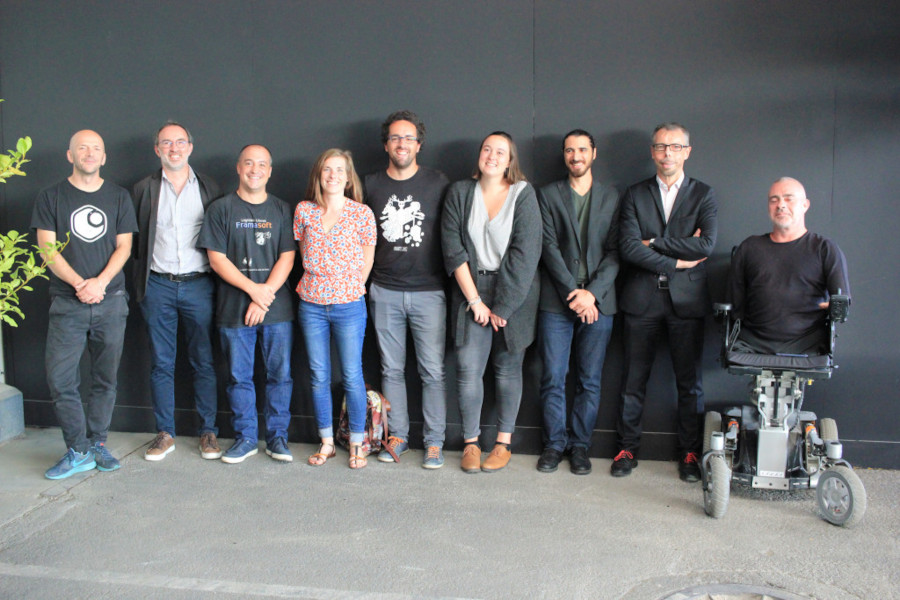 Personnes représentant le consortium à l'origine du Hub CONUMM en 2019, souriante et alignées devant un mur.